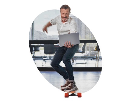 Mann fährt im Büro mit Longboard und Laptop herum symbolisch für einfach anwendbare Pakete.